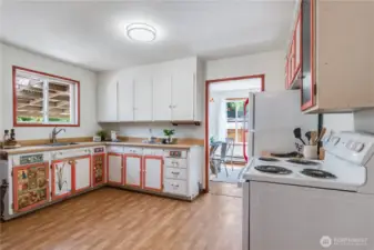 This spacious country kitchen allows several people to create meals together. The owner's artistic designs add a cheerful touch.