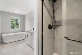 The primary bathroom also features a beautifully tiled shower and custom fixtures.