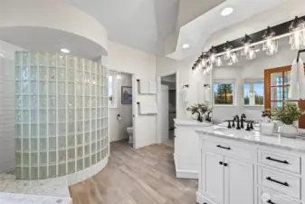 With a large walk-in shower, separate vanities, a toilet room...