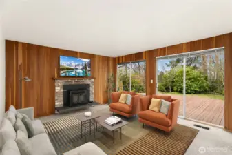 Here is your second living room, virtually staged.  There is a fireplace insert, sliding glass door and window.  The garage door opens into this room and the laundry room is part of the living room too.