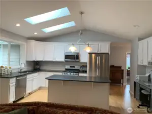 I love this kitchen. It has an expansive, hardwood floor and stainless appliances. It has granite countertops, too.  Gas cooktop