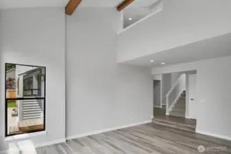 Soaring ceilings highlighted by wood beams create a striking architectural feature in the living room.