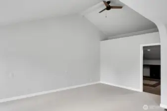 The vaulted ceiling in one section of the primary bedroom enhances the sense of space. Door leads to the spacious closet.
