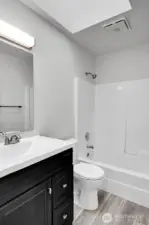 The ADU features a full bathroom with a skylight, providing ample natural light.