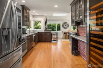 Massive, bright kitchen, remodeled in 2020, with tons of cabinet and granite counters, new stainless appliances including two oven ranges, gas cooktop, large wine refrigerator, walk-in pantry, and large skylight.