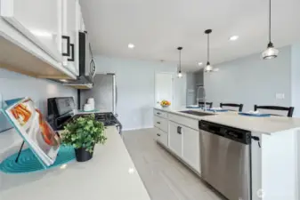 Note the quartz counters, Stainless steel appliances, and large pantry tucked under the stairs!