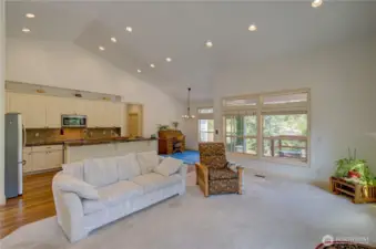 In the living room looking towards the kitchen, dining room and hallway to the primary suite and laundry room. There is a covered porch off the dining room. This home is available partially furnished.