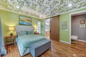 New barn door leading into the completely remodeled primary bath. Fun wallpaper ceiling!