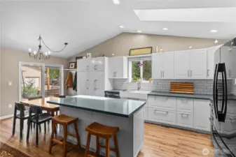 Updated Kitchen w/White Cabinets, Stainless and Black Appliances, Quartz Counters and Tile Backsplash. Island sits 2 - very convenient for a breakfast spot!