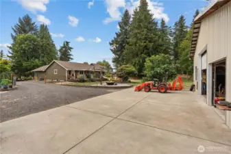 View of the Backyard w/Paved Parking in front of the Shop