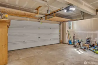 Attached 2 car garage with overhead storage and area to add a work bench.