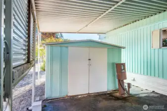 Convenient storage shed under the carport keeps tools, garden items, and seasonal décor neatly organized.