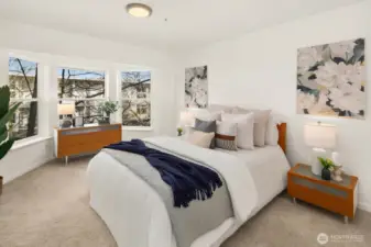 Spacious primary bedroom with bay window and dedicated custom closet area