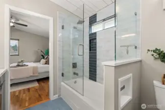 Fabulous tiled tub shower with contemporary hardware and window for added light/ventilation.