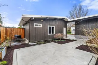Isn't this a pretty place for quiet thoughts - or summer BBQs. At one time, there was a hot tub to the left of the garage/ADU, where you see the table and chairs now. White door leads into finished garage storage with loft above. Windows at center and left are part of the ADU.