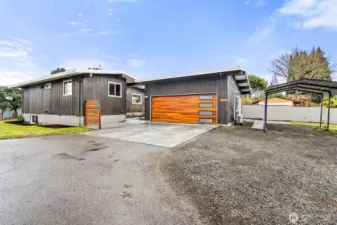 From the alley that runs along the north property boundary - courtyard patio is just through that space between house and garage. Private ADU entrance is on the right side of the garage. Lots of parking, and carport stays with the property.