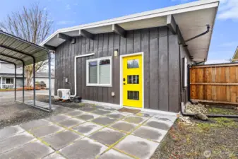 Private sunny entrance and patio for the ADU. Notice the ductless mini-split and around the right corner is the gas tankless water heater.