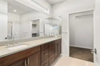 The attached bathroom is a spa-like escape, featuring high-end fixtures, a sleek vanity, and a spacious walk-in shower.