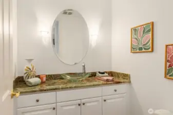The powder room with custom lighting, beautiful granite counters and glass bowl.