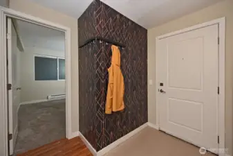 The foyer for this ground level condo includes a wall mounted coat rack.