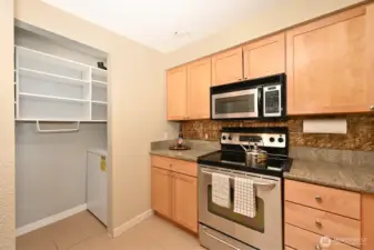 The kitchen appliances are stainless steel and the washer & dryer are in an alcove to the left.