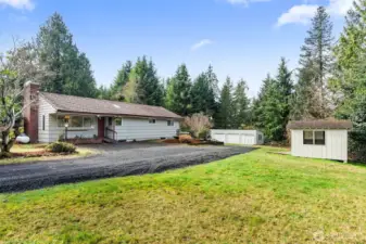 Property is over an acre and includes home, 3-bay detached garage with left-side garden storage, and a garden shed and dog house (on the left side)