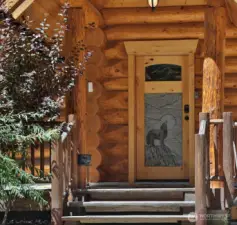 Custom wood entry with carved wildlife detail sets the tone for this authentic mountain lodge.