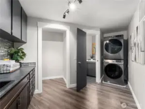 Versatile walk-through laundry room featuring a bathroom, sink area, and ample storage.