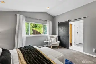 Chic barn door opens to a beautiful ensuite bathroom and walk-in closet.