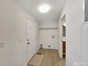 The laundry room has a built-in shelf for storage, convenient access to the bathroom, and direct entry from the porch—designed for everyday functionality.