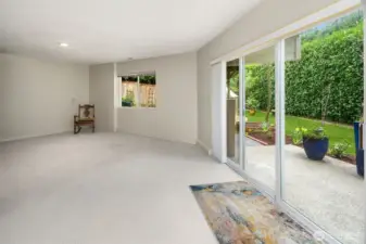 lower level features a versatile rec room with sliding doors that open to a side patio