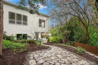 a paved path leading to the flagstone patio