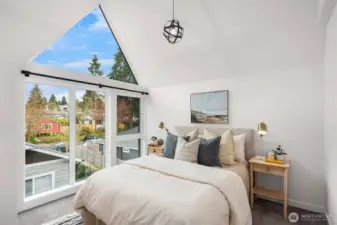 Vaulted ceilings and abundant natural light elevate the primary bedroom.