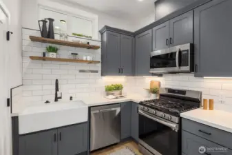 Well-appointed kitchen with large farmhouse sink, stainless appliances and an efficient layout.