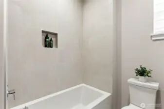 Upstairs hall bathroom with the tub and full height tile surround.