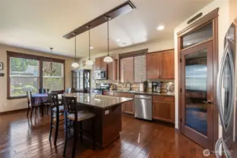 Kitchen at end of entry with walk in pantry next to refrigerator