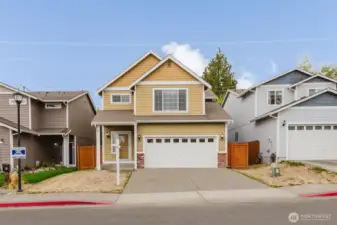 Welcoming front view of this charming two-story home with covered entry and two-car garage.