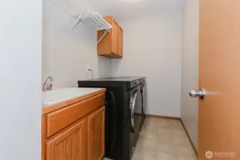 Laundry room with storage cabinetry and utility sink.