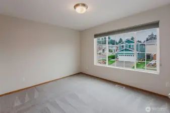 Additional bedroom with carpet and natural light.