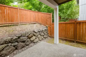 Private backyard patio with rock wall detail.