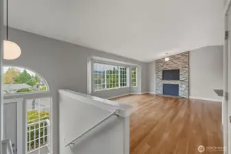 View of the entry, living room w/bay window and stone re-faced, wood-burning fireplace