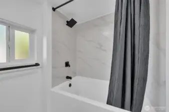 Primary bathroom with its own deep tub and new tile!