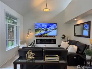 Bright and inviting family room with soaring vaulted ceilings, large windows for natural lighting, and an open, airy feel - perfect for relaxing or entertaining.