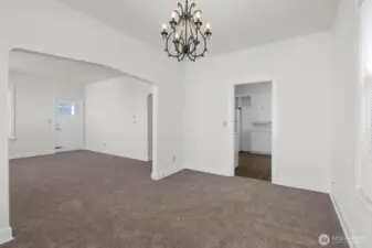 Upper-level dining area with living room to the left and kitchen to the right.