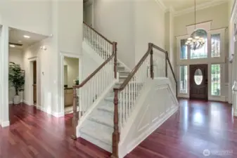 The double entrance grand staircase is a breathtaking centerpiece that elevates the entire home with timeless elegance and architectural flair. Flowing symmetrically from both sides, it creates a dramatic and graceful ascent to the upper level, perfect for making a lasting impression. This statement feature not only enhances the home's open and airy feel but also adds a sense of grandeur typically found in luxury estates.Tucked just off the base of the staircase, a private hall leads to the expansive primary suite, offering a quiet retreat with both convenience and seclusion.