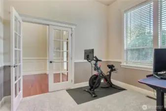 Classic French doors open to a flexible space perfect for a home office or a formal sitting room.