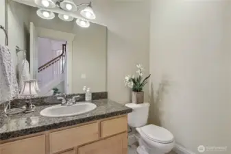 The main floor half guest bath is thoughtfully tucked into a cozy cove, offering privacy for your visitors. Its discreet location ensures a little extra comfort, guests can freshen up without feeling like the whole house hears every little tinkle.