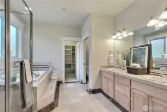 The large, solid French doors offer a grand and elegant entrance into your marbled, spa-like retreat. This atmosphere is thoughtfully designed to pamper and refresh.   The deep jetted tub is for soothing hydrotherapy, a large glass shower, and a private water closet for added comfort and discretion. Completing this space is an extremely spacious walk-in closet, beautifully outfitted with custom built-ins to keep everything organized and within reach. Your personal sanctuary is tucked within the heart of the home.