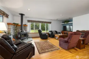 Cozy living room complete with a wood stove and hand cut stone backing.