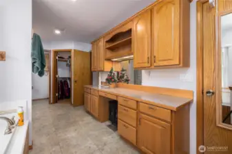 His and Hers separate closets plus a built in makeup mirror with shelving.